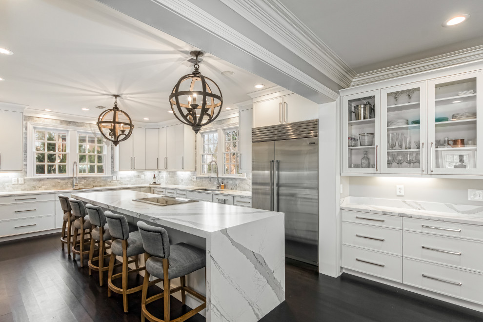 Expansive classic u-shaped kitchen in Columbus with flat-panel cabinets, white cabinets, stainless steel appliances, an island, a submerged sink, dark hardwood flooring, brown floors and white worktops.