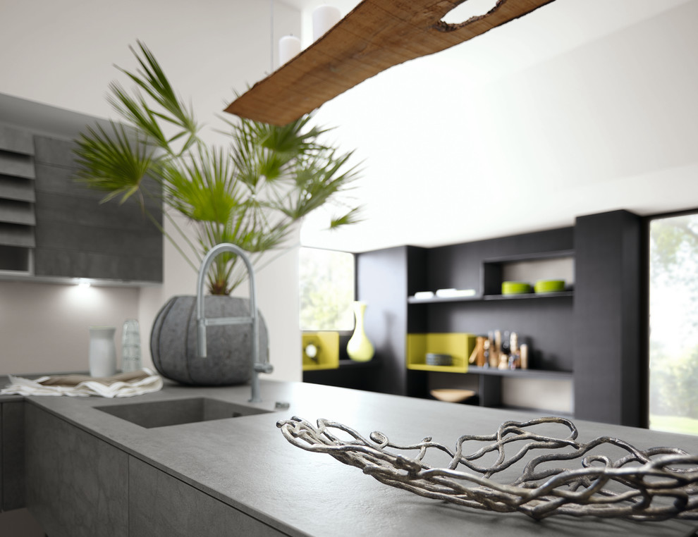 Immagine di una cucina minimalista di medie dimensioni con lavello integrato, ante lisce, ante grigie, top in superficie solida, paraspruzzi grigio, paraspruzzi con lastra di vetro e penisola