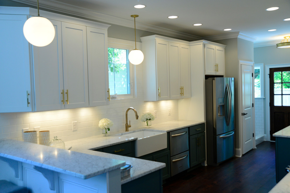 Example of a mid-sized transitional galley dark wood floor eat-in kitchen design in Charleston with a farmhouse sink, shaker cabinets, white cabinets, marble countertops, white backsplash, ceramic backsplash, stainless steel appliances and a peninsula
