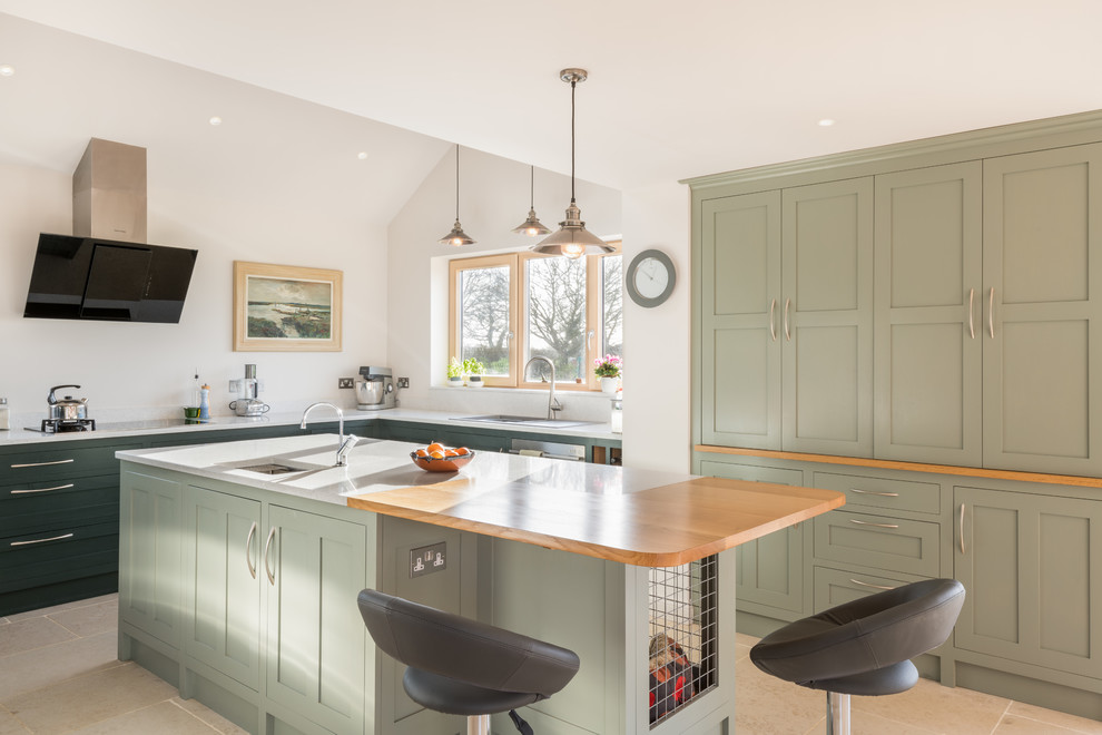 Inspiration for a beach style l-shaped kitchen in Other with a built-in sink, shaker cabinets, green cabinets, white splashback, an island, beige floors and white worktops.