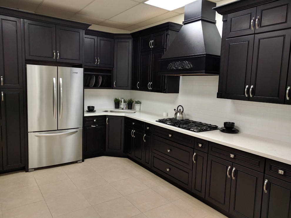 Example of a large transitional l-shaped ceramic tile and beige floor kitchen design in Phoenix with an undermount sink, beaded inset cabinets, black cabinets, quartzite countertops, white backsplash, subway tile backsplash, stainless steel appliances and no island