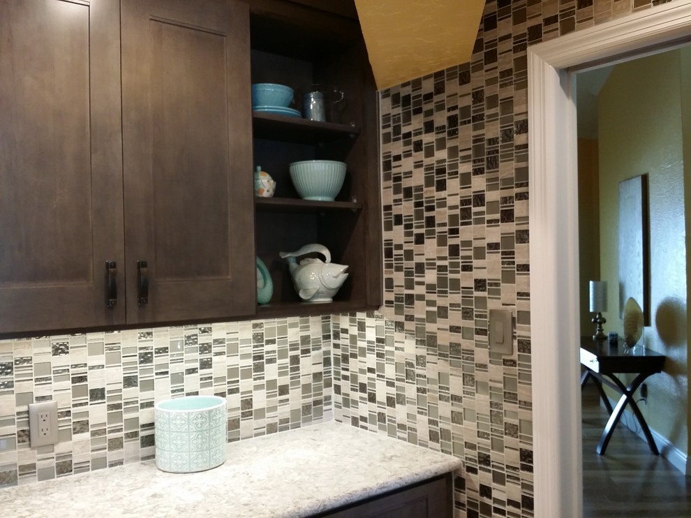 Foto de cocina comedor lineal clásica renovada grande con fregadero de doble seno, puertas de armario de madera oscura, salpicadero con mosaicos de azulejos, electrodomésticos de acero inoxidable, una isla, armarios con paneles empotrados, encimera de granito, salpicadero multicolor, suelo de madera clara y suelo beige