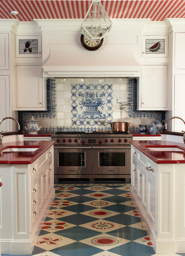 Example of a cottage u-shaped multicolored floor kitchen design in New York with white cabinets, multicolored backsplash, an undermount sink, recessed-panel cabinets, stainless steel appliances, two islands and red countertops