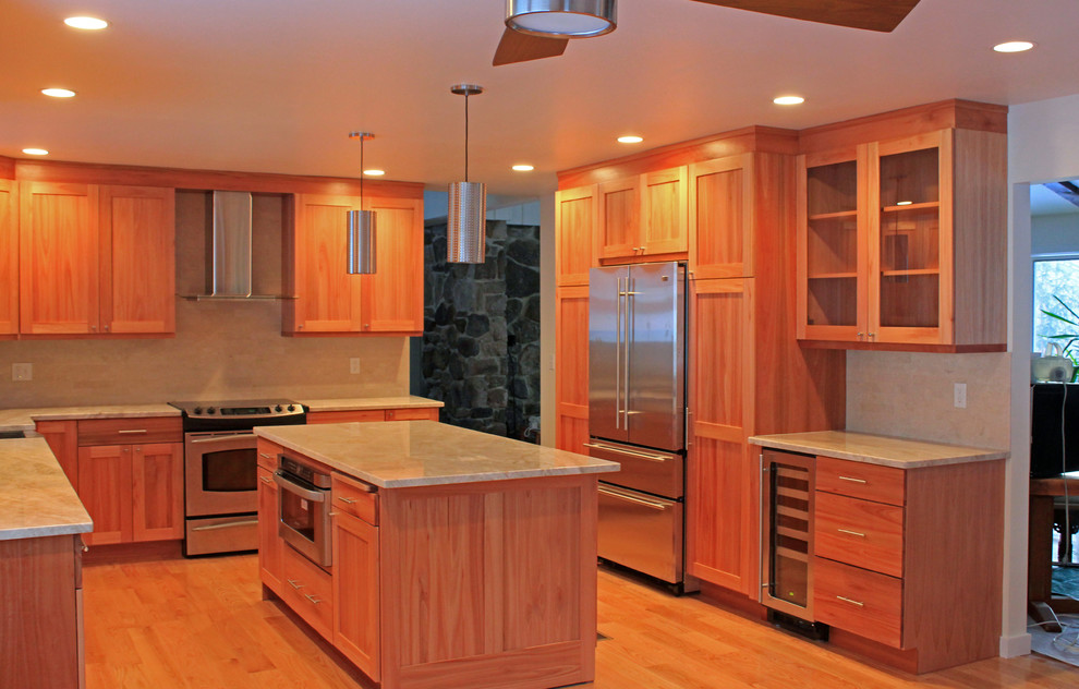 Foto på ett funkis u-kök, med en undermonterad diskho, skåp i shakerstil, skåp i ljust trä, granitbänkskiva, grått stänkskydd, stänkskydd i stenkakel, rostfria vitvaror, ljust trägolv och en köksö