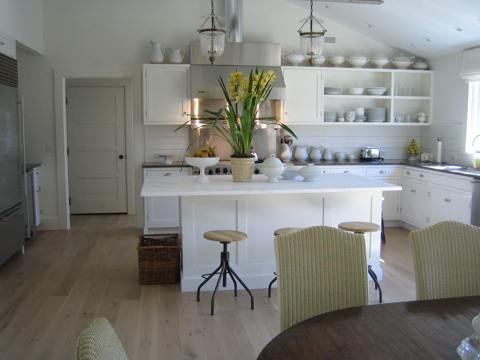 Bild på ett avskilt, mellanstort vintage u-kök, med en undermonterad diskho, skåp i shakerstil, vita skåp, marmorbänkskiva, vitt stänkskydd, rostfria vitvaror, ljust trägolv och en köksö