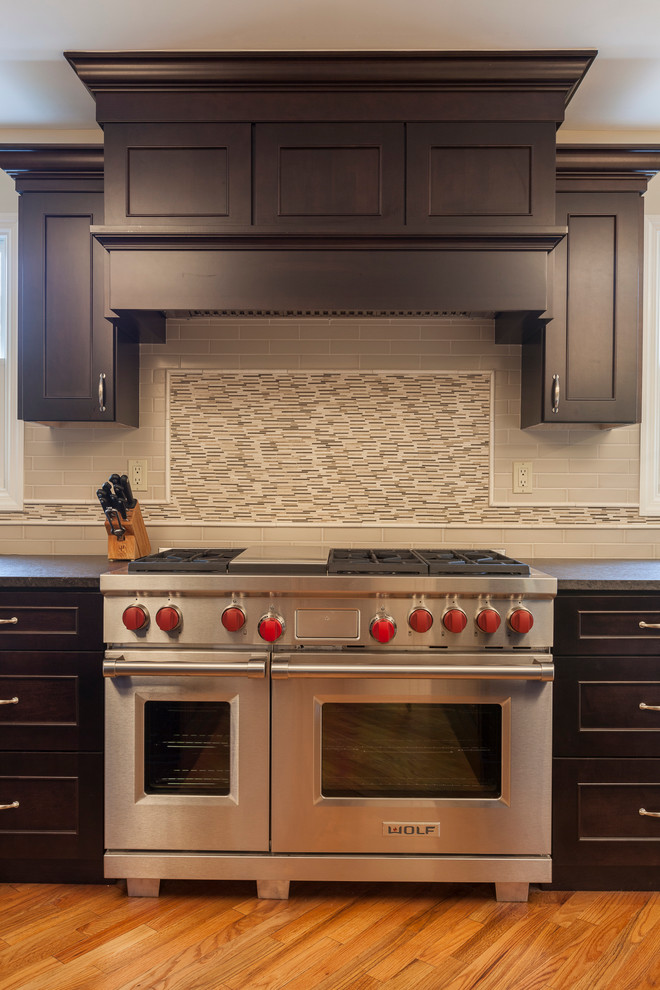 Exempel på ett mycket stort klassiskt kök, med en undermonterad diskho, släta luckor, vita skåp, granitbänkskiva, vitt stänkskydd, stänkskydd i keramik, rostfria vitvaror, ljust trägolv och flera köksöar