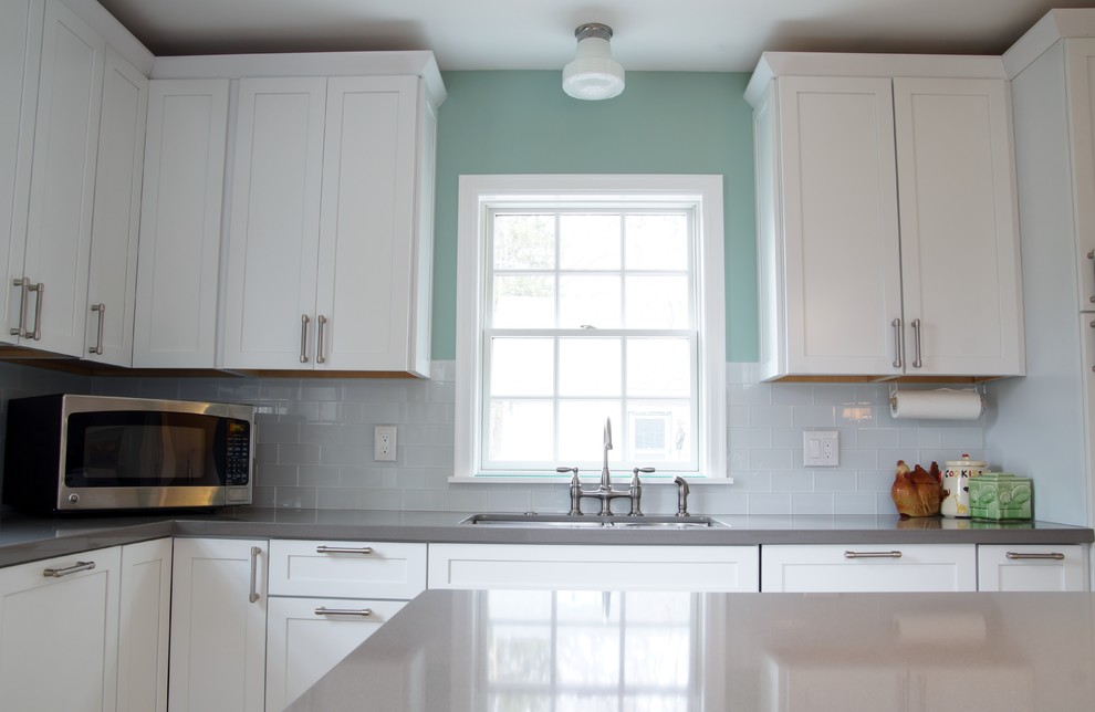 Exempel på ett stort modernt kök och matrum, med en nedsänkt diskho, vita skåp, bänkskiva i kvarts, vitt stänkskydd, stänkskydd i glaskakel, rostfria vitvaror, ljust trägolv och en köksö
