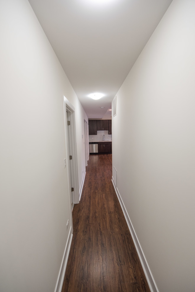 На фото: маленький коридор: освещение в классическом стиле с белыми стенами, полом из ламината, коричневым полом, любым потолком и любой отделкой стен для на участке и в саду