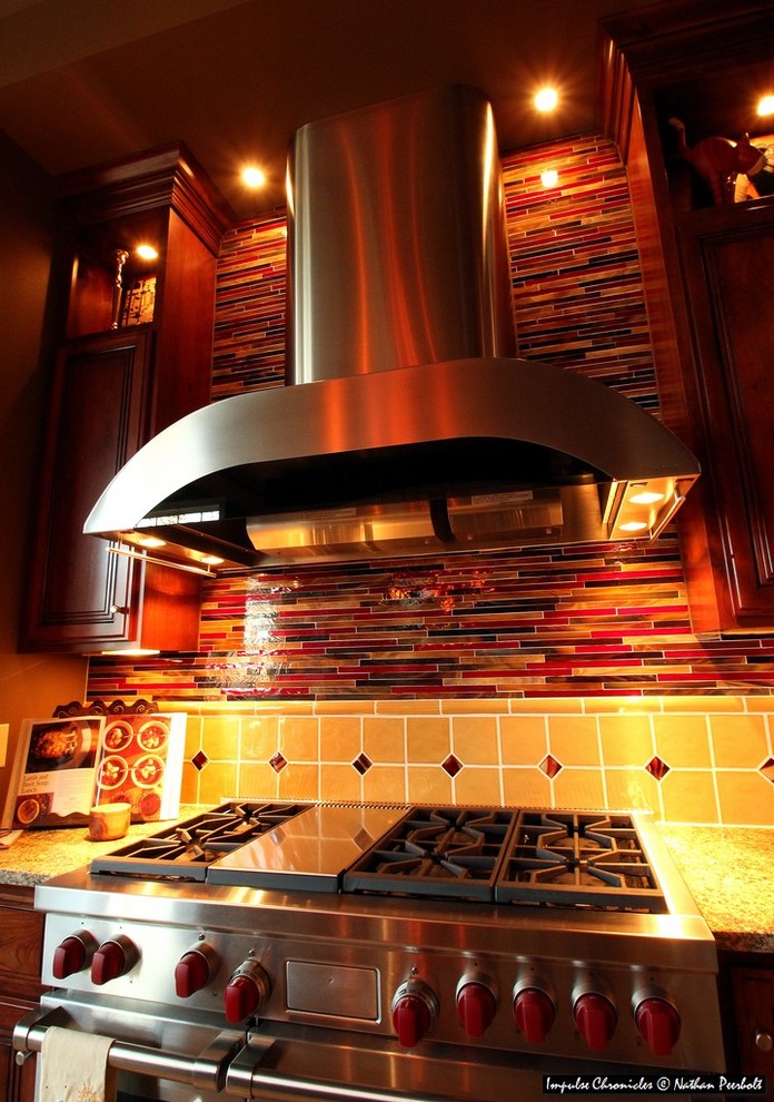 Immagine di una grande cucina chic con ante in legno bruno, top in granito, paraspruzzi giallo, paraspruzzi con piastrelle di vetro, elettrodomestici in acciaio inossidabile e pavimento in gres porcellanato