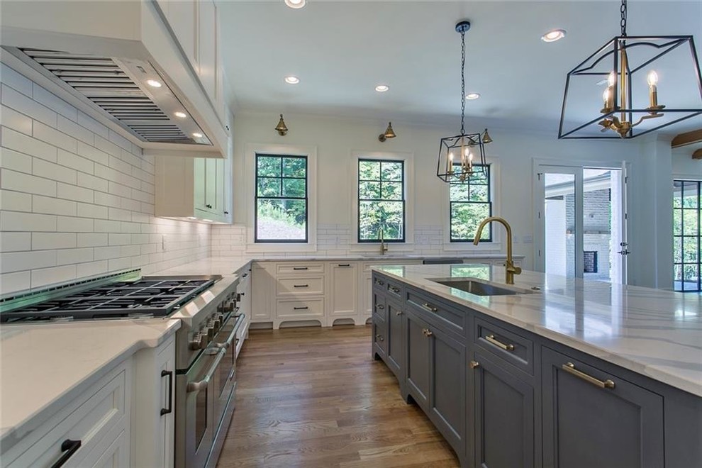 Eat-in kitchen - large transitional galley light wood floor and gray floor eat-in kitchen idea in Atlanta with a single-bowl sink, recessed-panel cabinets, gray cabinets, quartzite countertops, white backsplash, ceramic backsplash, stainless steel appliances, an island and gray countertops
