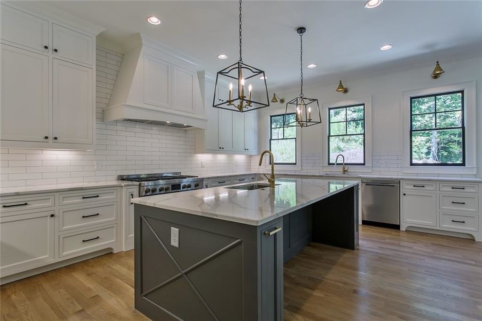 Inspiration for a large transitional galley light wood floor and gray floor eat-in kitchen remodel in Atlanta with a single-bowl sink, recessed-panel cabinets, gray cabinets, quartzite countertops, white backsplash, ceramic backsplash, stainless steel appliances, an island and gray countertops