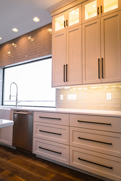 Große Moderne Küche in U-Form mit Landhausspüle, Schrankfronten im Shaker-Stil, weißen Schränken, Küchenrückwand in Grau, Glasrückwand, Küchengeräten aus Edelstahl, dunklem Holzboden, Kücheninsel und braunem Boden in Seattle