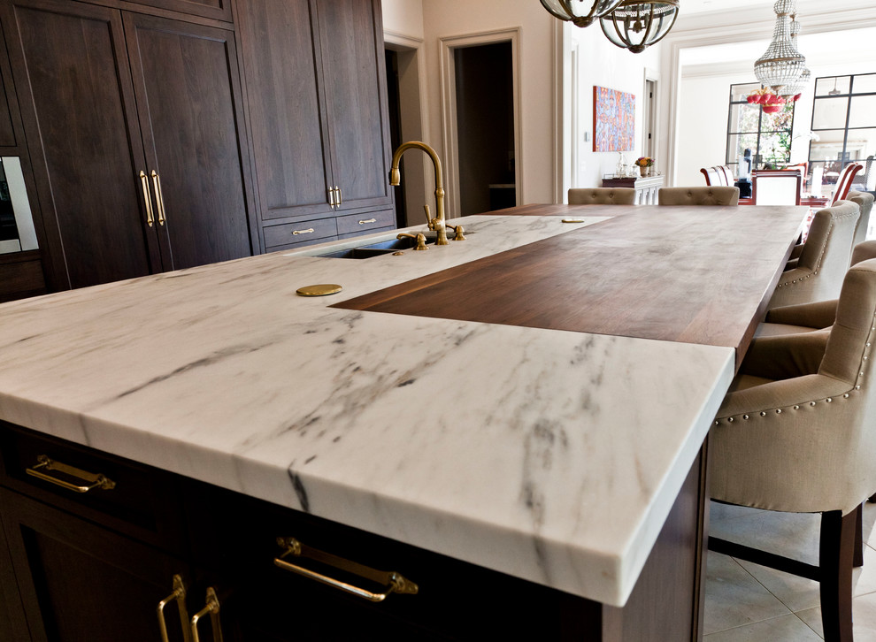 Inspiration for a large transitional l-shaped marble floor and beige floor eat-in kitchen remodel in Atlanta with an undermount sink, recessed-panel cabinets, dark wood cabinets, marble countertops, gray backsplash, stone slab backsplash, paneled appliances and an island