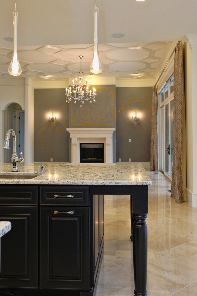Klassisk inredning av ett mycket stort flerfärgad flerfärgat kök, med en undermonterad diskho, granitbänkskiva, grått stänkskydd, stänkskydd i sten, rostfria vitvaror, marmorgolv, en köksö, svarta skåp, luckor med infälld panel och beiget golv