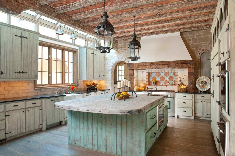 Tuscan kitchen photo in Dallas with paneled appliances, a farmhouse sink, distressed cabinets, soapstone countertops and multicolored backsplash