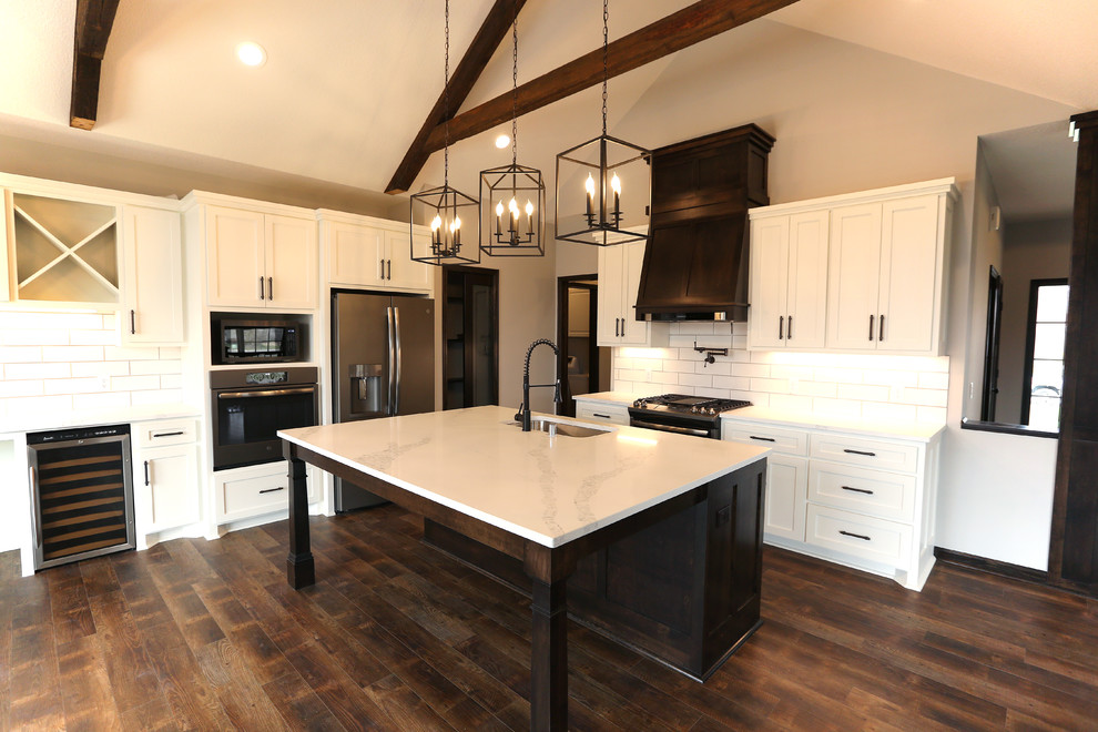 Large arts and crafts l-shaped vinyl floor and brown floor open concept kitchen photo in Minneapolis with an undermount sink, shaker cabinets, white cabinets, quartz countertops, white backsplash, subway tile backsplash, stainless steel appliances, an island and white countertops