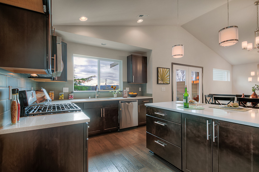 Example of a mid-sized minimalist l-shaped light wood floor eat-in kitchen design in Seattle with an undermount sink, shaker cabinets, dark wood cabinets, quartzite countertops, gray backsplash, subway tile backsplash, stainless steel appliances and an island