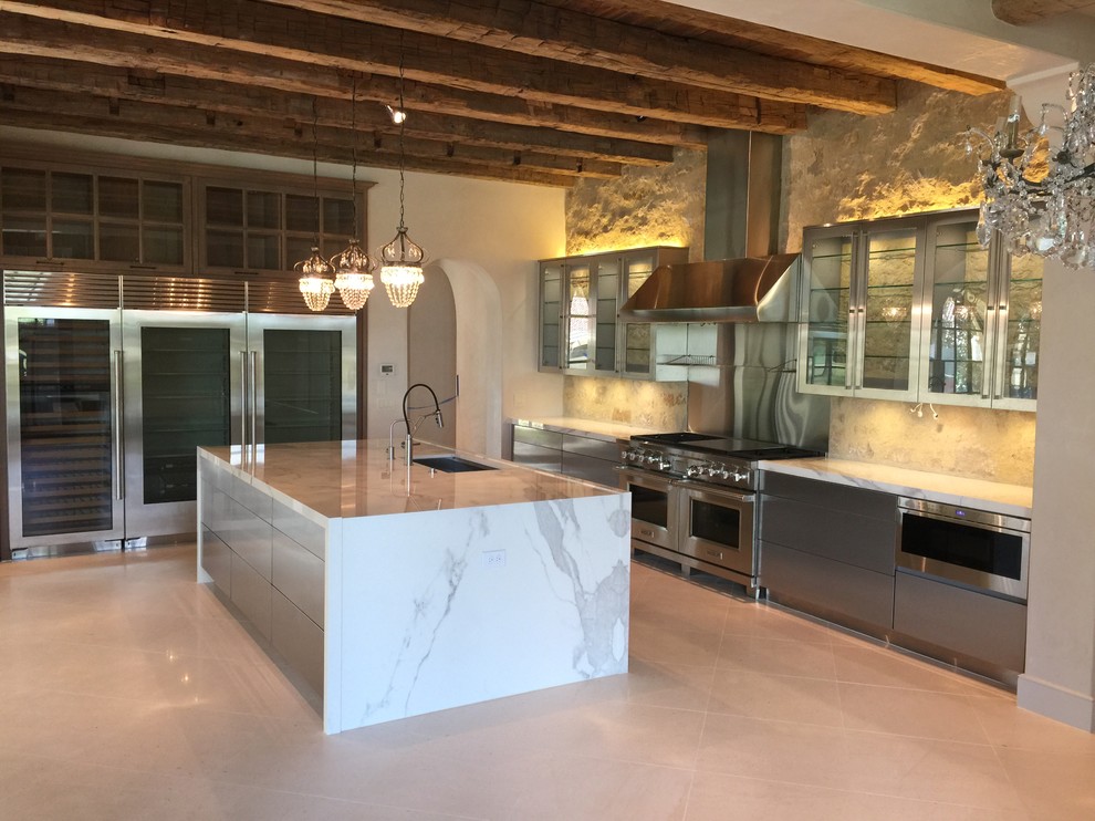 Bild på ett mellanstort funkis linjärt kök och matrum, med en dubbel diskho, släta luckor, skåp i rostfritt stål, marmorbänkskiva, beige stänkskydd, stänkskydd i stenkakel, rostfria vitvaror, marmorgolv och en köksö