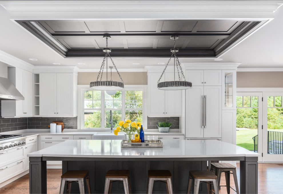 Idéer för att renovera ett stort funkis grå grått kök, med en rustik diskho, luckor med infälld panel, vita skåp, bänkskiva i kvarts, grått stänkskydd, stänkskydd i keramik, rostfria vitvaror, mellanmörkt trägolv, en köksö och brunt golv