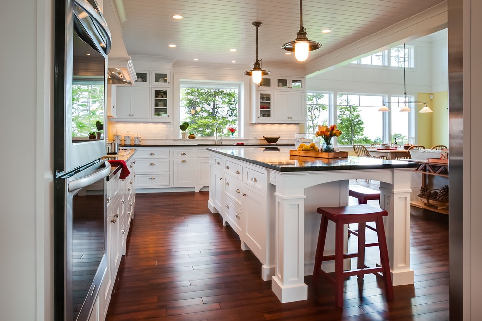 Immagine di una cucina ad ambiente unico tradizionale con ante in stile shaker, ante bianche, paraspruzzi bianco e elettrodomestici in acciaio inossidabile