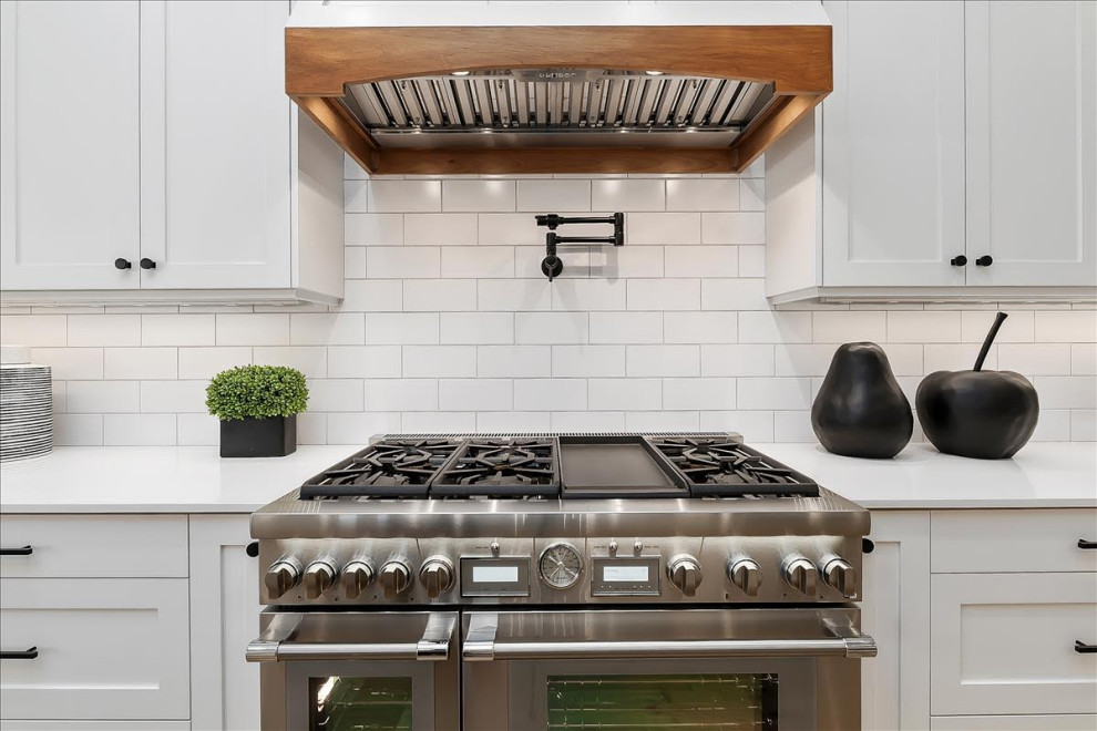Inspiration for a large country u-shaped light wood floor and beige floor eat-in kitchen remodel in Boise with a farmhouse sink, recessed-panel cabinets, white cabinets, quartzite countertops, white backsplash, subway tile backsplash, stainless steel appliances, an island and white countertops