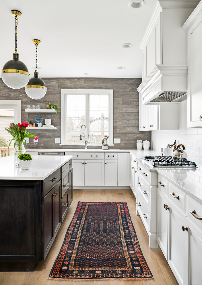 Inspiration for a cottage light wood floor and beige floor kitchen remodel in Chicago with an undermount sink, recessed-panel cabinets, white cabinets, white backsplash, subway tile backsplash, stainless steel appliances, an island and white countertops
