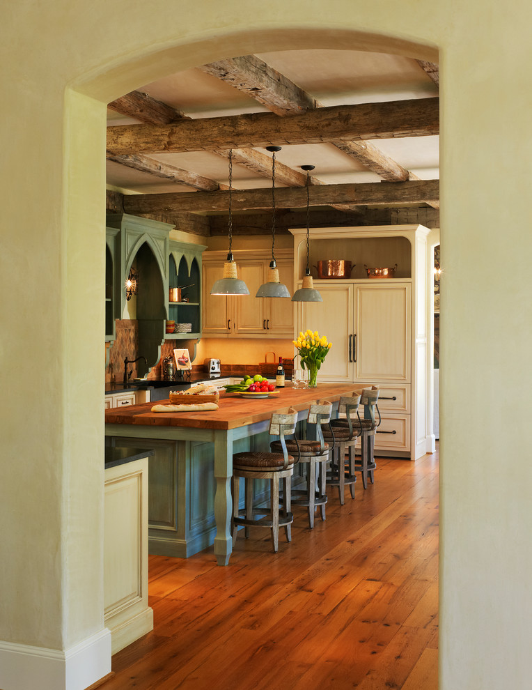 ワシントンD.C.にある地中海スタイルのおしゃれなキッチン (木材カウンター、パネルと同色の調理設備、緑のキャビネット、エプロンフロントシンク、落し込みパネル扉のキャビネット、濃色無垢フローリング) の写真