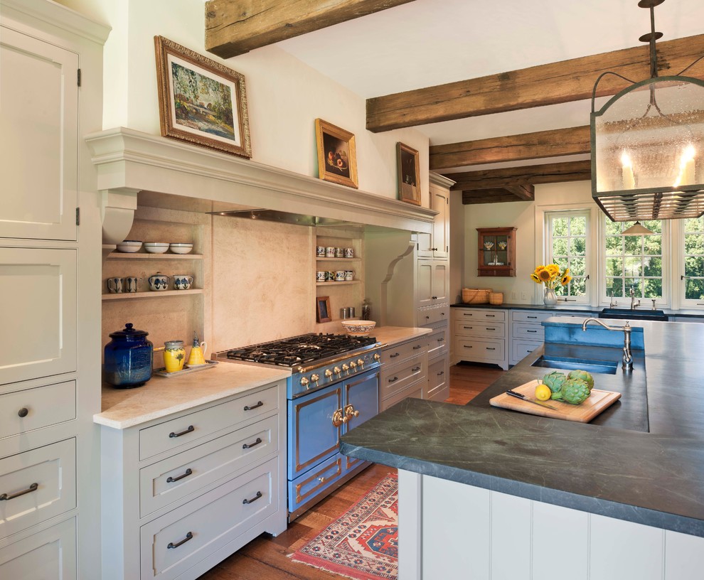 Réalisation d'une cuisine champêtre avec un évier encastré, un placard avec porte à panneau encastré, des portes de placard beiges, une crédence beige et un électroménager de couleur.