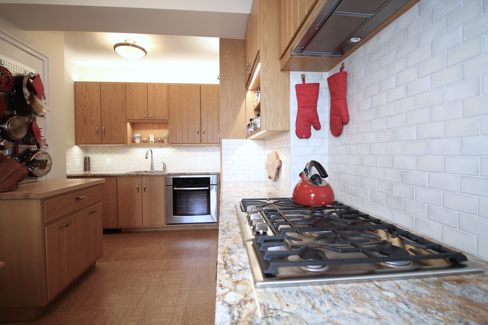 Mittelgroße Retro Küche mit Vorratsschrank, Unterbauwaschbecken, Küchenrückwand in Weiß, bunten Elektrogeräten, Korkboden und braunem Boden in New York