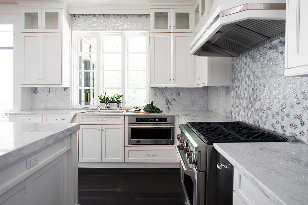 Exempel på ett mycket stort klassiskt kök, med en undermonterad diskho, luckor med infälld panel, vita skåp, bänkskiva i kvartsit, vitt stänkskydd, stänkskydd i stenkakel, rostfria vitvaror, mellanmörkt trägolv och en köksö