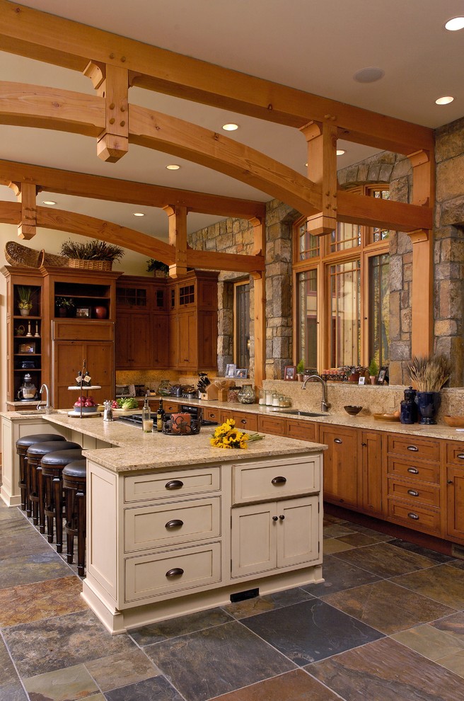 Inspiration för rustika l-kök, med en undermonterad diskho, luckor med infälld panel, skåp i mellenmörkt trä, skiffergolv och en köksö