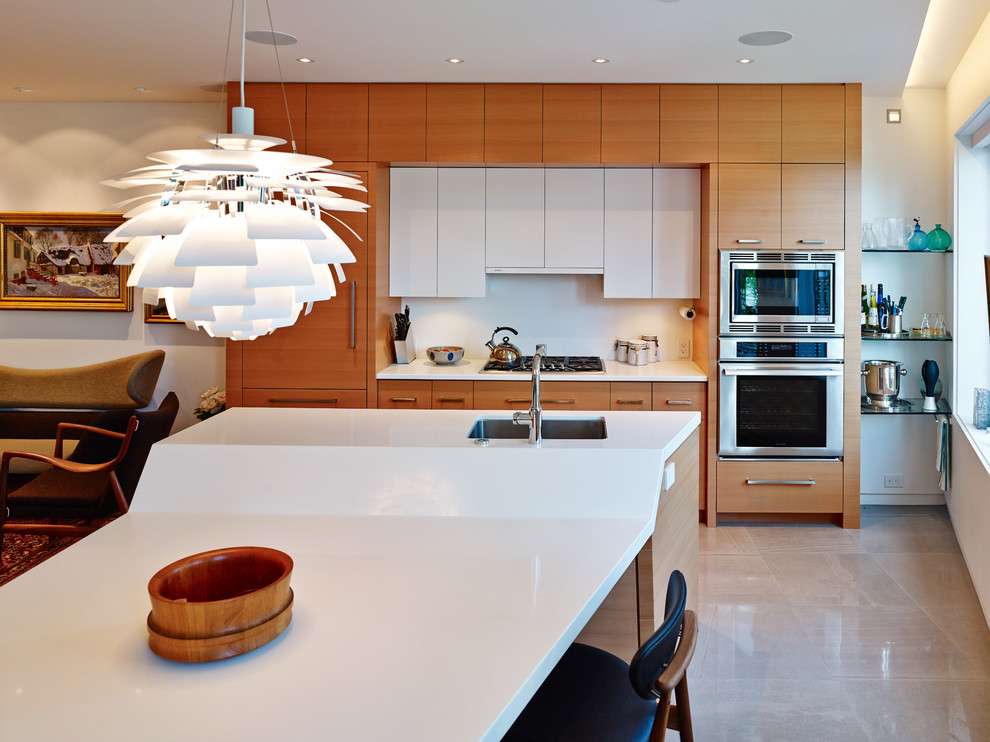 Zweizeilige Moderne Küche mit Unterbauwaschbecken, flächenbündigen Schrankfronten, hellen Holzschränken, Küchenrückwand in Weiß, Küchengeräten aus Edelstahl und Marmor-Arbeitsplatte in Vancouver