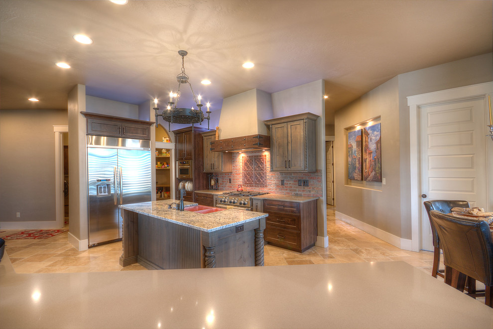 Foto på ett mellanstort rustikt flerfärgad kök, med en rustik diskho, skåp i shakerstil, granitbänkskiva, rött stänkskydd, stänkskydd i tegel, rostfria vitvaror, travertin golv, en köksö, beiget golv och grå skåp