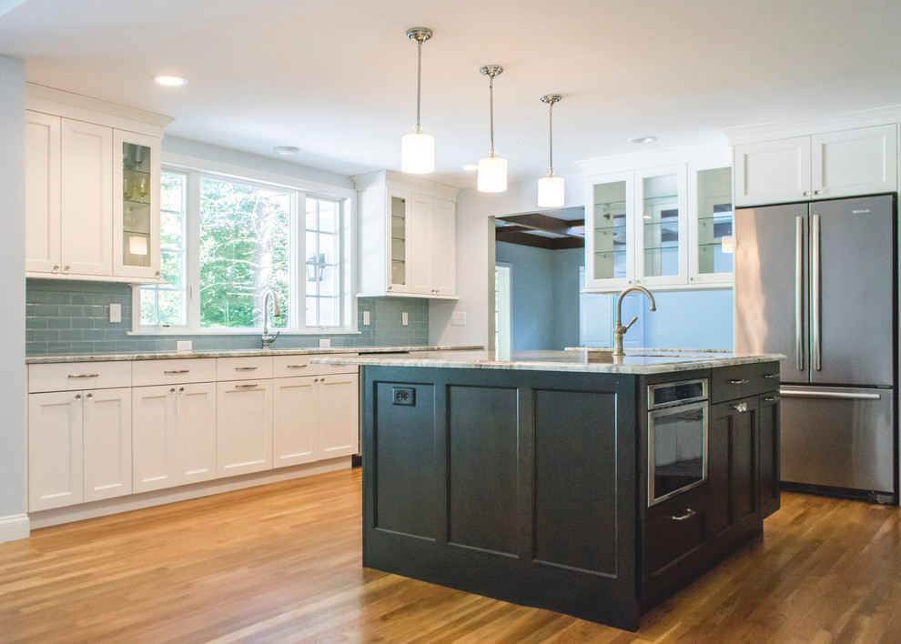 Example of a huge transitional l-shaped light wood floor kitchen design in Boston with an undermount sink, shaker cabinets, white cabinets, granite countertops, blue backsplash, porcelain backsplash, stainless steel appliances and an island