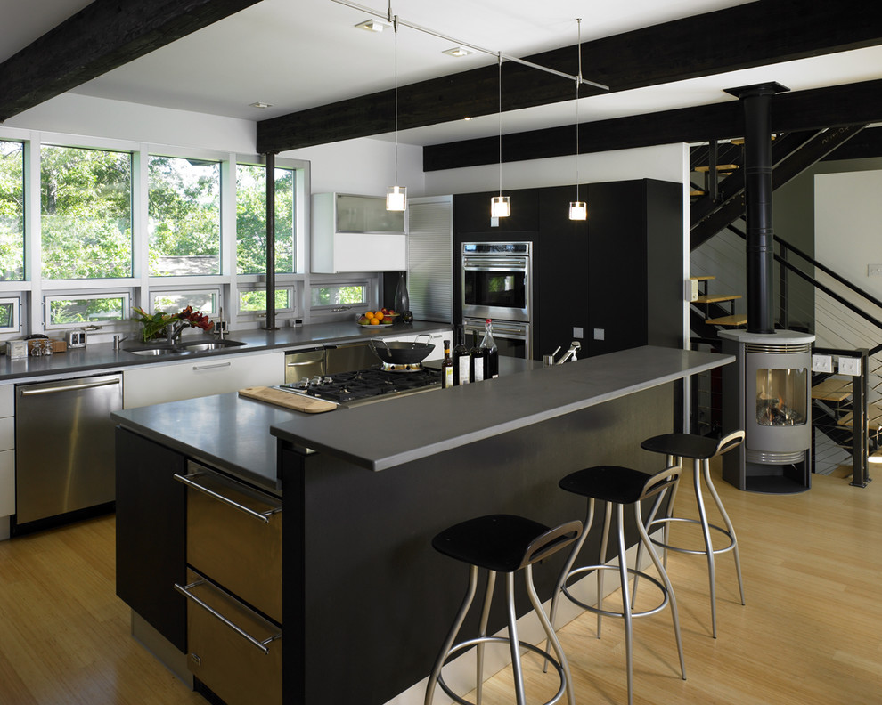 Imagen de cocina rectangular actual con electrodomésticos de acero inoxidable, fregadero bajoencimera y con blanco y negro