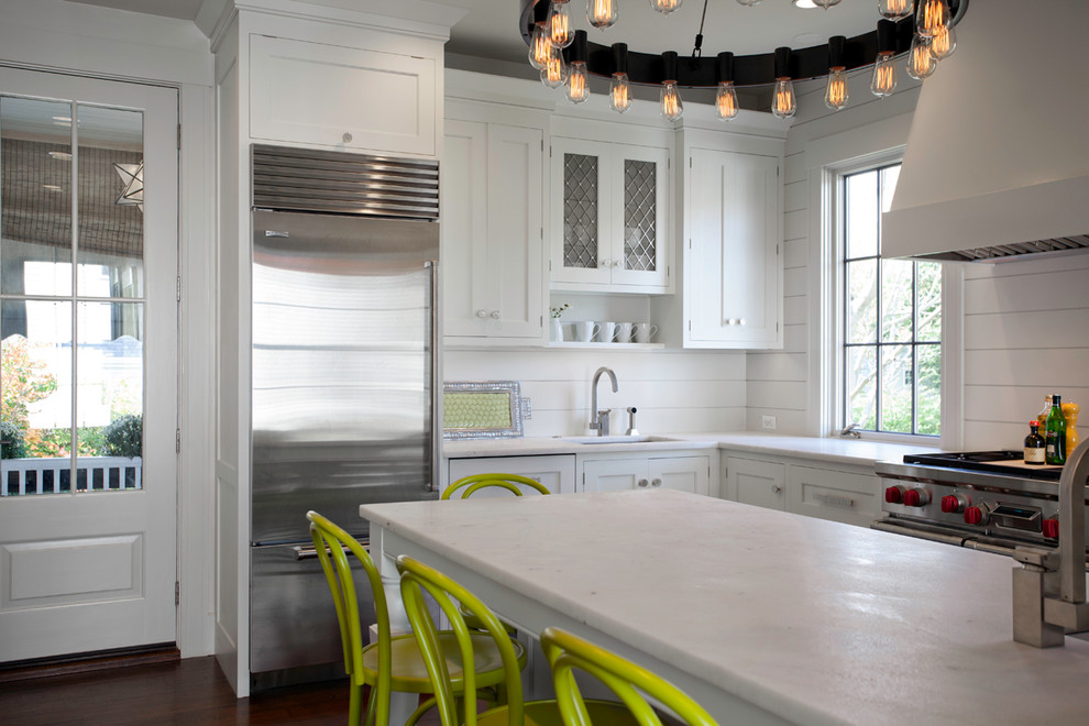 Foto de cocina clásica renovada con fregadero bajoencimera, armarios estilo shaker, puertas de armario blancas, salpicadero blanco y electrodomésticos de acero inoxidable
