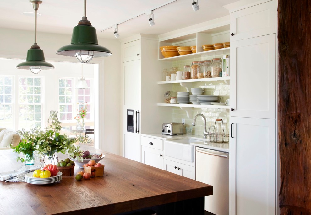 Example of a classic kitchen design in New York with a farmhouse sink, wood countertops, open cabinets, white cabinets and subway tile backsplash
