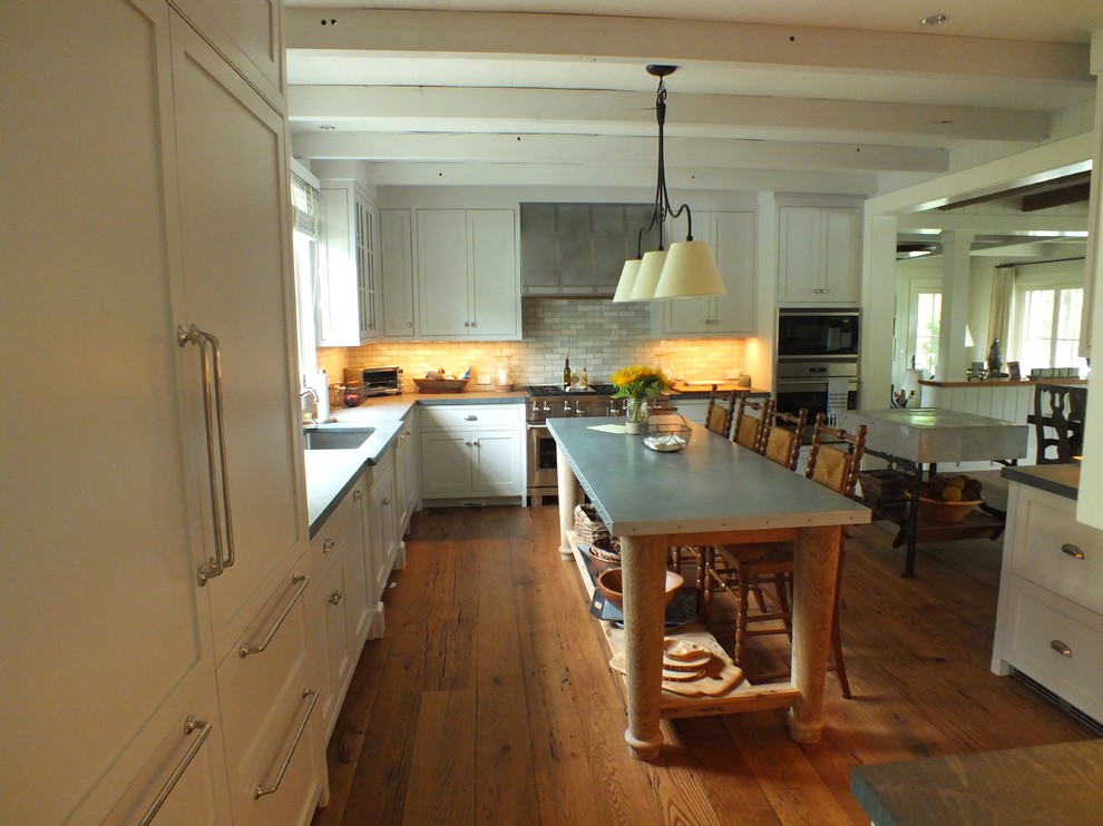 Exempel på ett mellanstort klassiskt l-kök, med en undermonterad diskho, skåp i shakerstil, vita skåp, bänkskiva i kalksten, flerfärgad stänkskydd, stänkskydd i terrakottakakel, integrerade vitvaror, mellanmörkt trägolv och flera köksöar