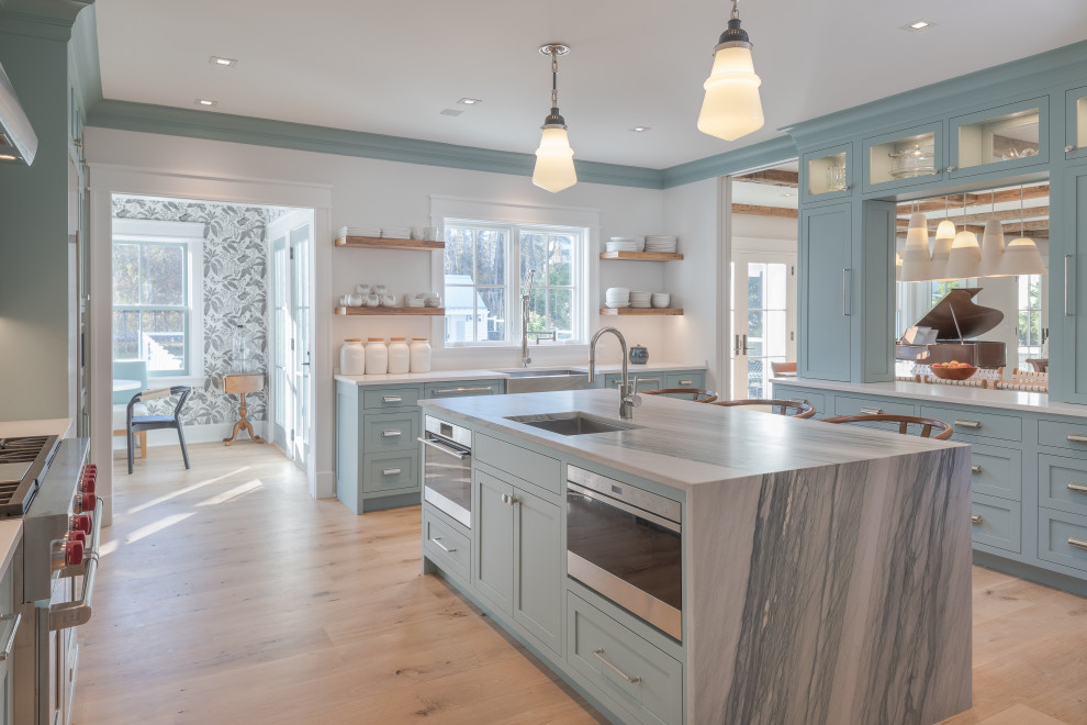 Eat-in kitchen - large country u-shaped light wood floor and beige floor eat-in kitchen idea in New York with a farmhouse sink, blue cabinets, marble countertops, white backsplash, marble backsplash, stainless steel appliances, an island, gray countertops and shaker cabinets