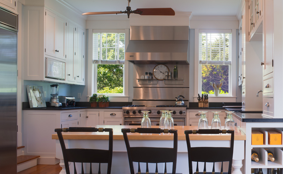 Immagine di una cucina costiera con lavello sottopiano, ante a filo, ante bianche, top in granito, paraspruzzi blu e elettrodomestici in acciaio inossidabile