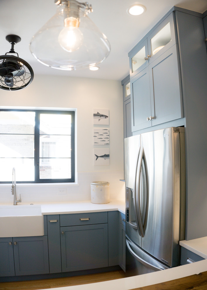Example of a mid-sized arts and crafts kitchen design in Denver with an undermount sink, shaker cabinets, blue cabinets, quartz countertops, white backsplash, subway tile backsplash and stainless steel appliances