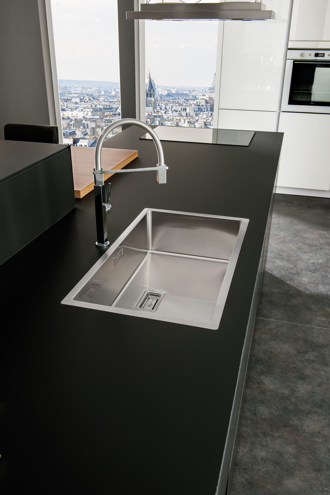 Foto di una cucina design di medie dimensioni con lavello da incasso, ante di vetro, ante bianche, top in laminato e elettrodomestici in acciaio inossidabile