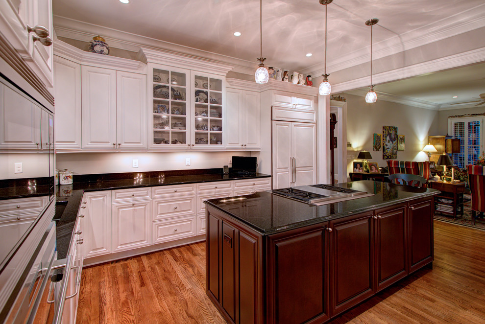 Inspiration for a large timeless l-shaped medium tone wood floor eat-in kitchen remodel in Charlotte with an undermount sink, recessed-panel cabinets, white cabinets, onyx countertops, stainless steel appliances and an island