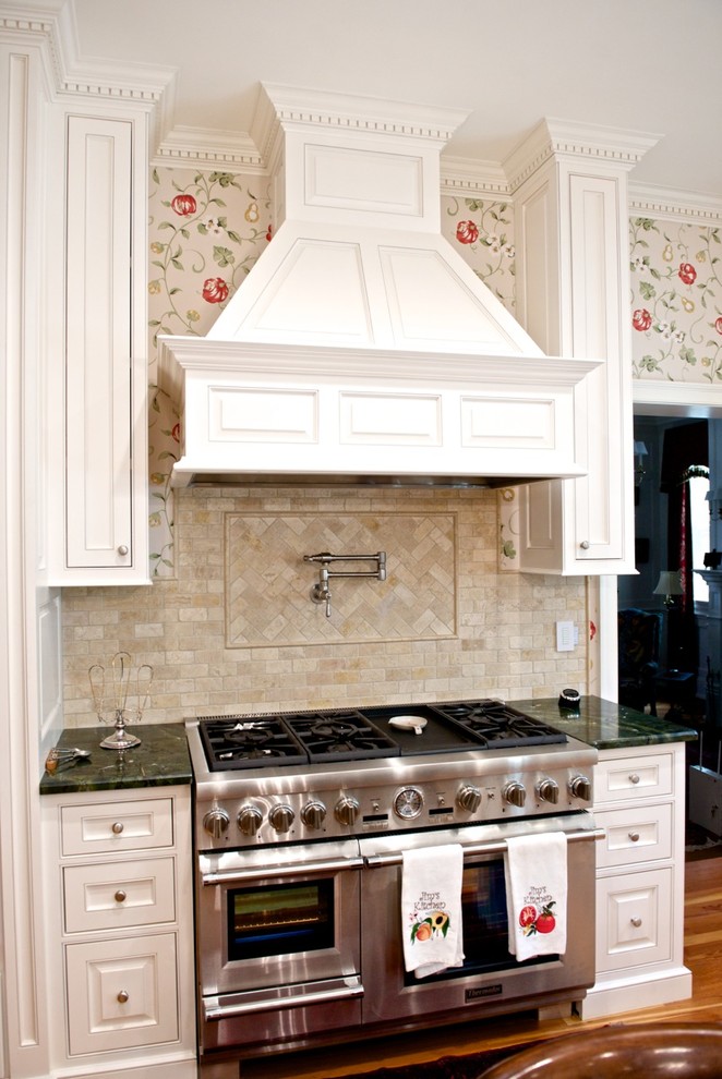 Foto på ett mycket stort vintage kök, med luckor med profilerade fronter, vita skåp, granitbänkskiva, beige stänkskydd, stänkskydd i keramik, integrerade vitvaror, ljust trägolv och en köksö