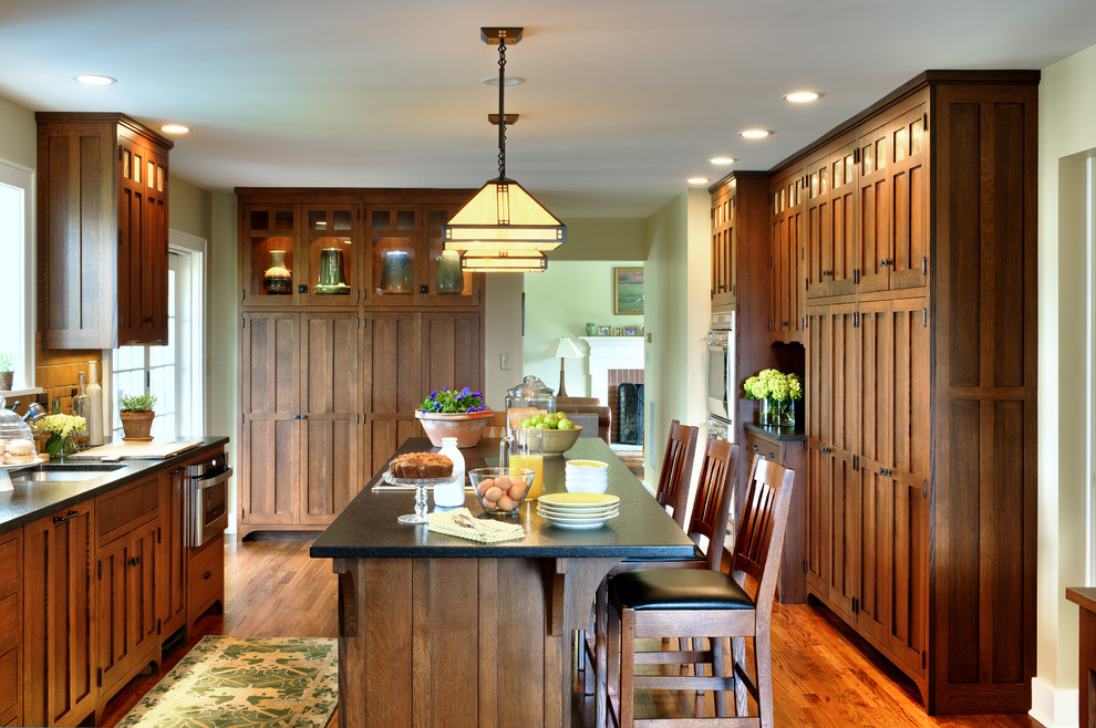 Urige Küche mit Unterbauwaschbecken, hellbraunen Holzschränken, Küchengeräten aus Edelstahl, braunem Holzboden und Kücheninsel in Bridgeport