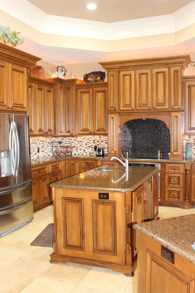 Bild på ett stort vintage kök, med en undermonterad diskho, luckor med upphöjd panel, skåp i mellenmörkt trä, bänkskiva i kvartsit, beige stänkskydd, stänkskydd i mosaik, rostfria vitvaror, travertin golv och flera köksöar