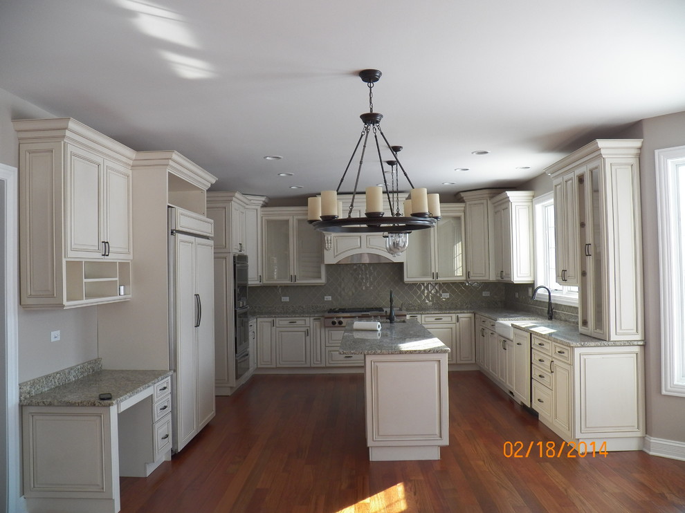 Design ideas for a traditional u-shaped kitchen in Chicago with white cabinets and medium hardwood flooring.