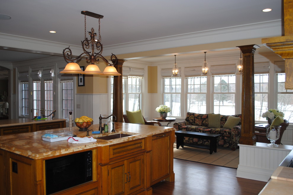 Photo of a large beach style kitchen in New York with a submerged sink, beaded cabinets, medium wood cabinets, marble worktops, multi-coloured splashback, wood splashback, integrated appliances, medium hardwood flooring, multiple islands and brown floors.