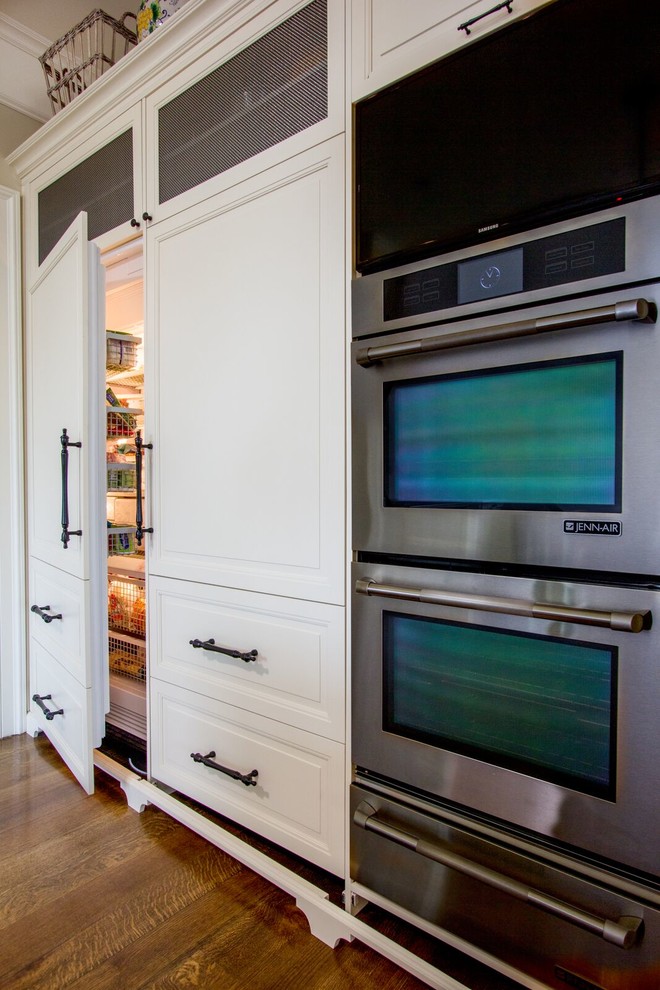 Foto di una grande cucina minimal con ante con riquadro incassato, ante bianche, elettrodomestici in acciaio inossidabile, pavimento in legno massello medio e pavimento marrone