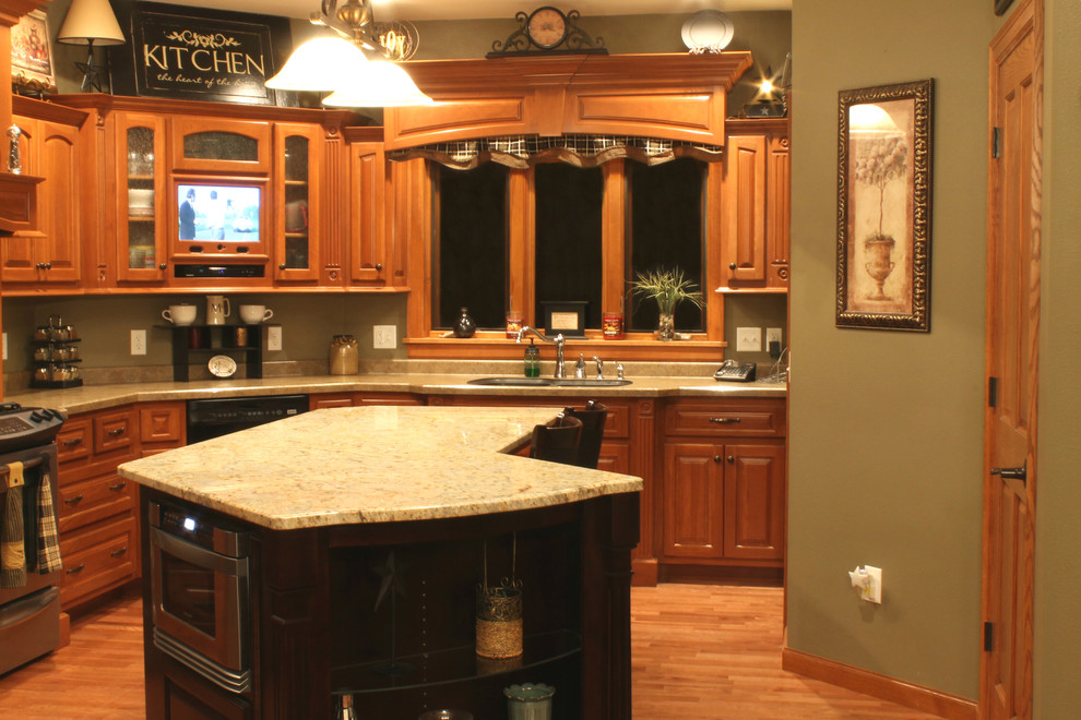 Esempio di una cucina classica di medie dimensioni con lavello sottopiano, ante con bugna sagomata, ante in legno scuro, elettrodomestici in acciaio inossidabile e top in granito